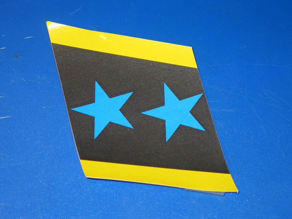 A blue and yellow After Burner Star Sticker - Right Hand Side on a blue surface.