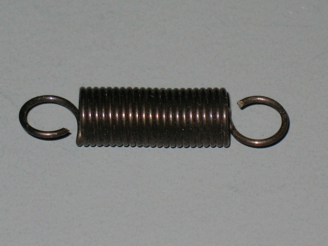 An Accelerator Spring on a white surface.