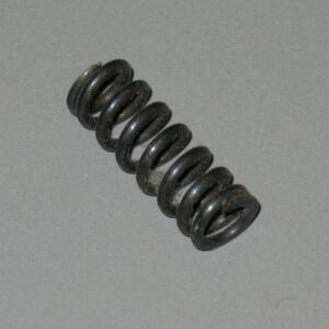 A small black metal coil spring on a gray surface.