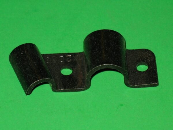 A black Accelerator Holder Bracket on a green surface.