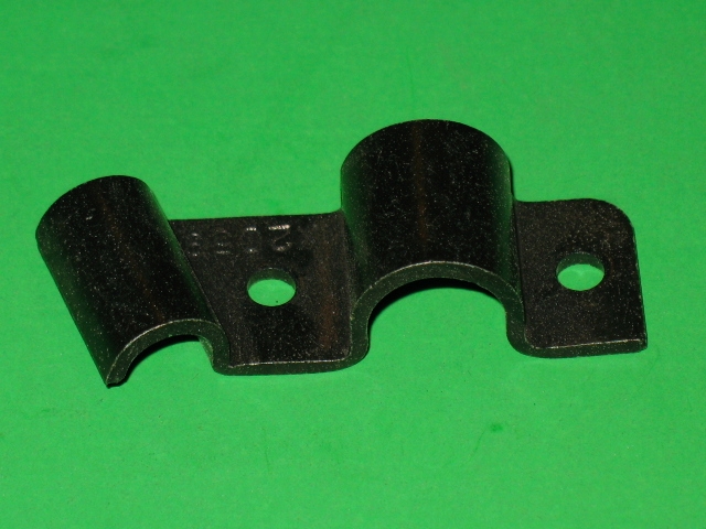 A black Accelerator Holder Bracket on a green surface.