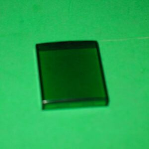A 523-5383-02 square piece of glass on a green surface.