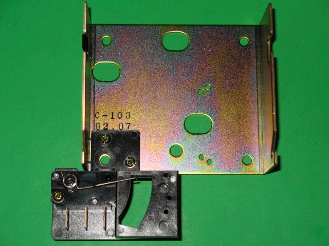 A metal plate with two 220-5086 screws and a piece of metal.