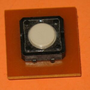 A small white 839-0016 Board, Switch, Laser Ghost on an orange piece of paper.
