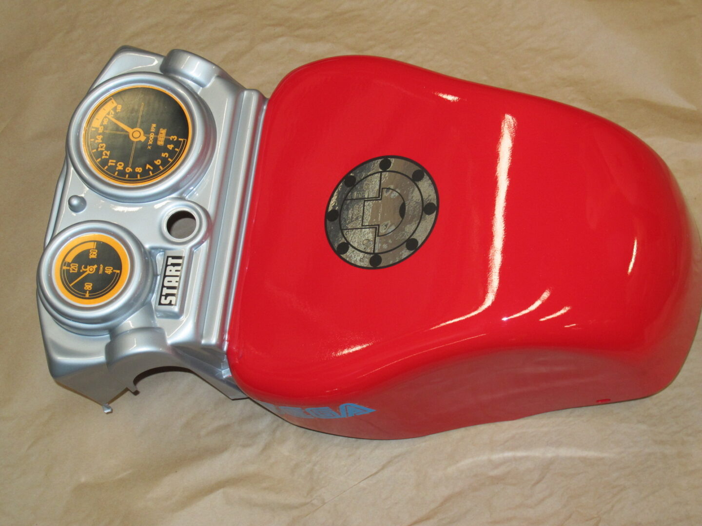 A red and silver Handle cover, 2 player, Red motorcycle with gauges on it.