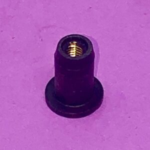 A Weld Nut on a purple surface.