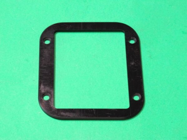 A black plastic Boot Holder on a green background.