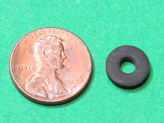 A penny next to a black Special washer.