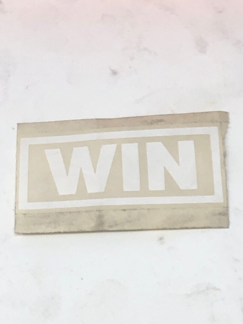 A white sticker with the word win on it.