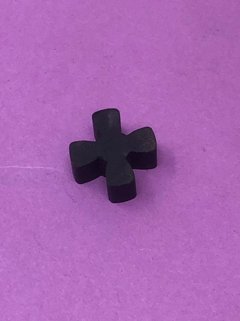 A black cross on a purple surface.