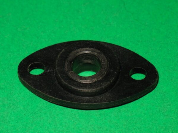 A black plastic 100-5015 nut on a green surface.