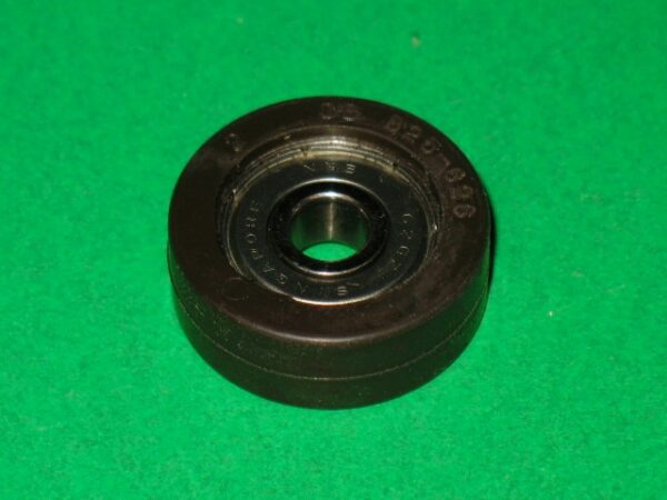 A black 100-5252 bearing on a green surface.