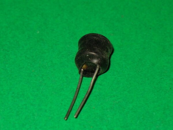 A small black coil on a green surface.