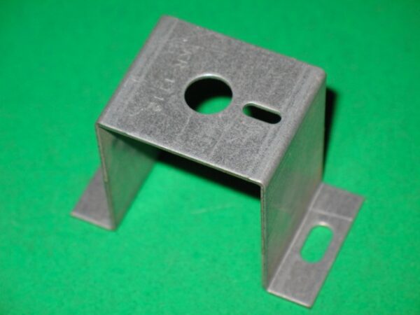 A bracket on a green surface.