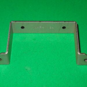 A metal Bracket on a green surface.