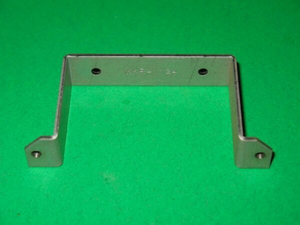 A metal Bracket on a green surface.