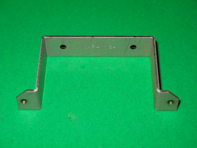 A metal Bracket on a green surface.