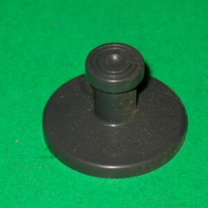 A black joystick on a green surface.