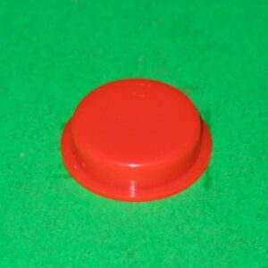 A red plastic Cast switch on a green surface.