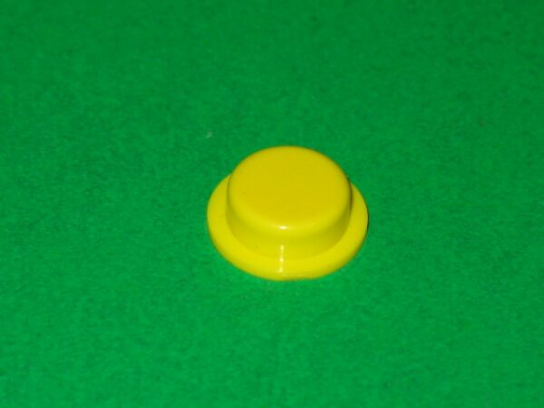 A yellow plastic Cap on a green surface.