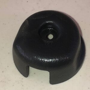 A black plastic Wheel Cover with a hole.