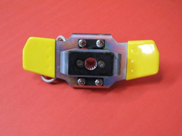 A yellow and black Butterfly Shifter Assembly holder on a red surface.