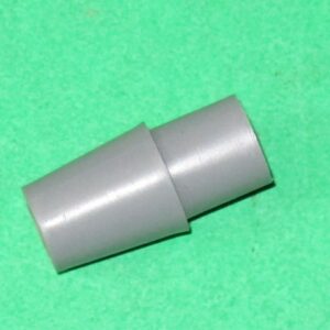 A gray plastic 4 way actuator for shaft on a green surface.