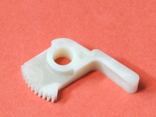 A white plastic Brake Gear with a hole in it.