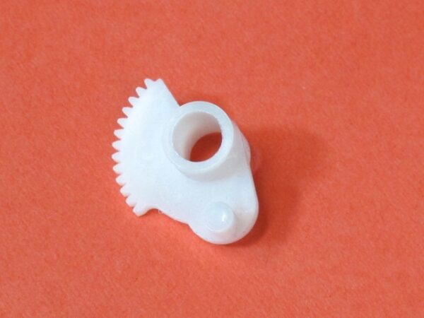 A small white Accel Gear on an orange surface.