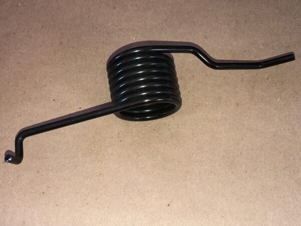 A black metal clutch spring on a table.