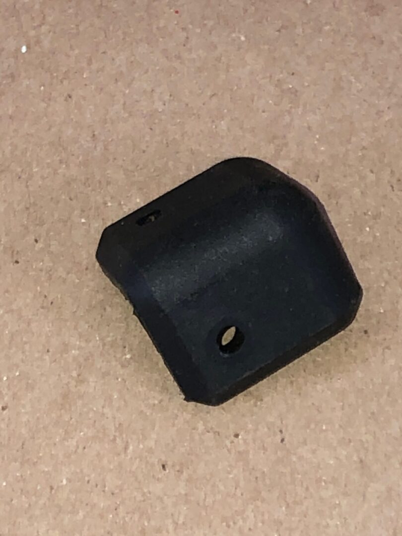 A black plastic Box Corner Pad on a table.