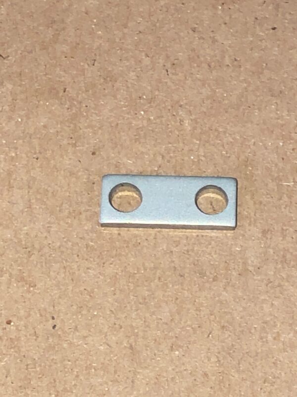 A small piece of metal called a Gear Spacer with two holes on it.