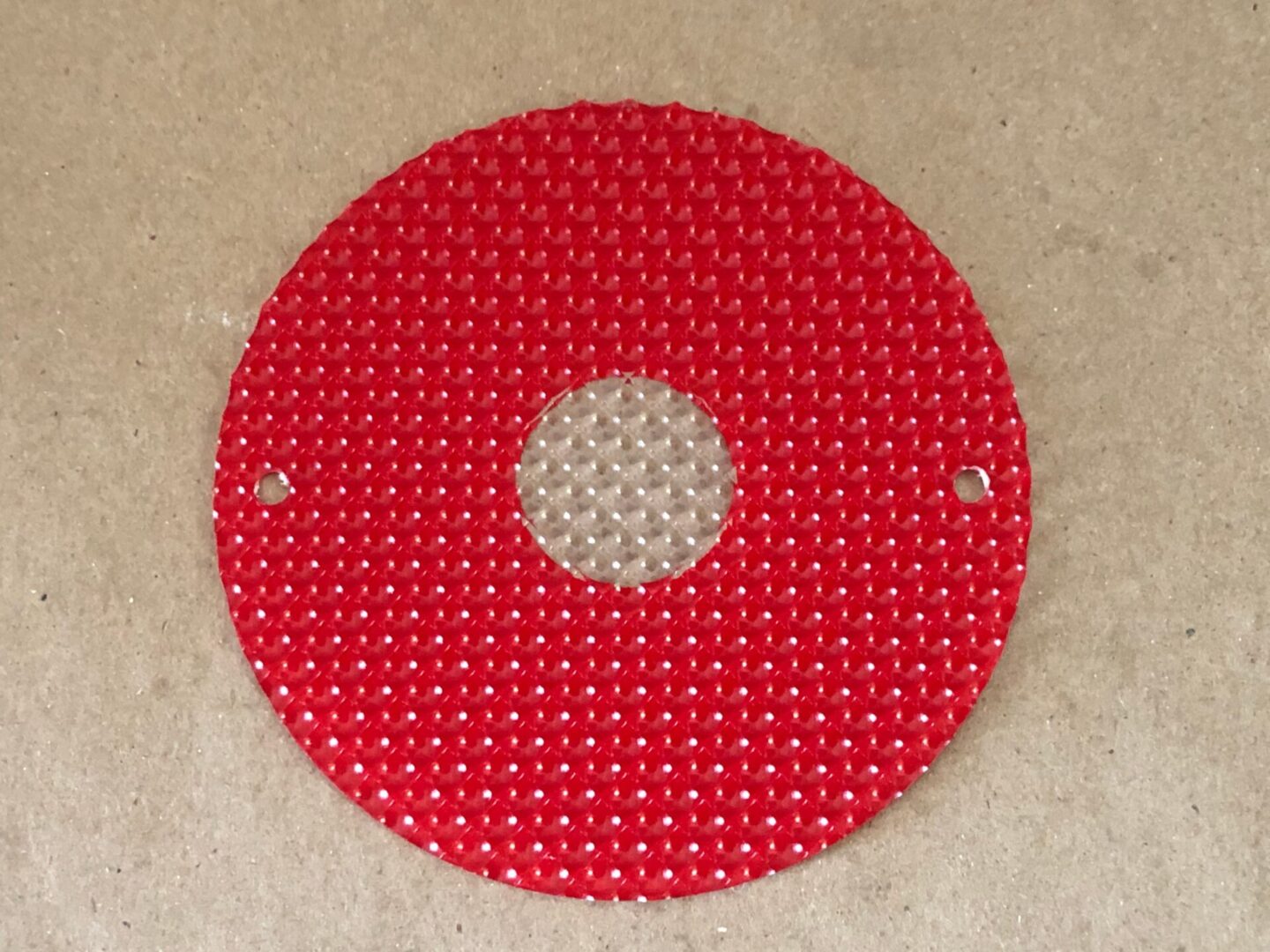 A red circular Rear Light Lens with a hole in it.