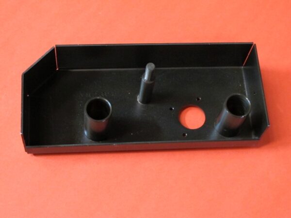 A black metal brake base with two holes on it.