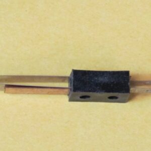 A small piece of Wico Leaf Switch, Cross Contacts on a yellow background.
