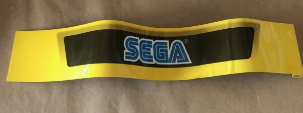 A yellow and black Sega logo sticker on a piece of paper.