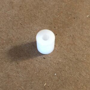 A white plastic roll pin sitting on a table.