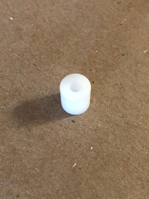 A white plastic roll pin sitting on a table.