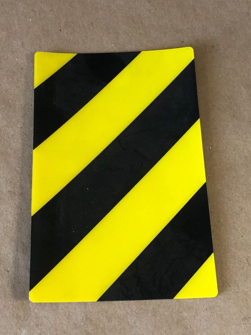 A yellow and black striped sticker on a table lid left.