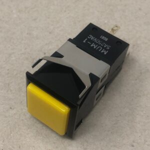 A black and yellow Square push Button on a surface.