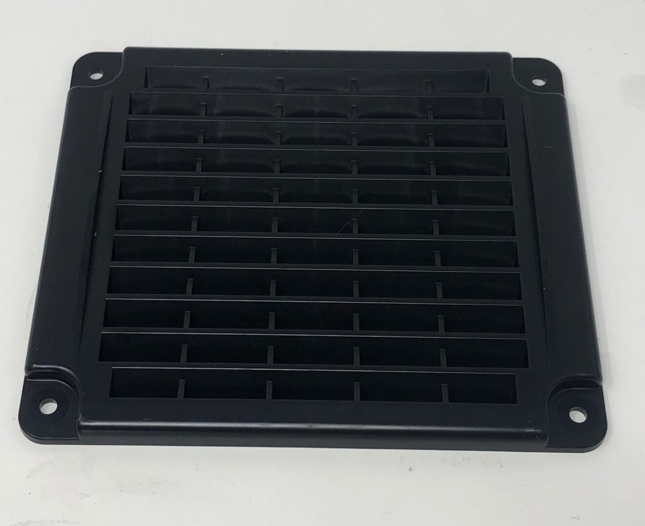 A black Air Vent Cover on a white surface.