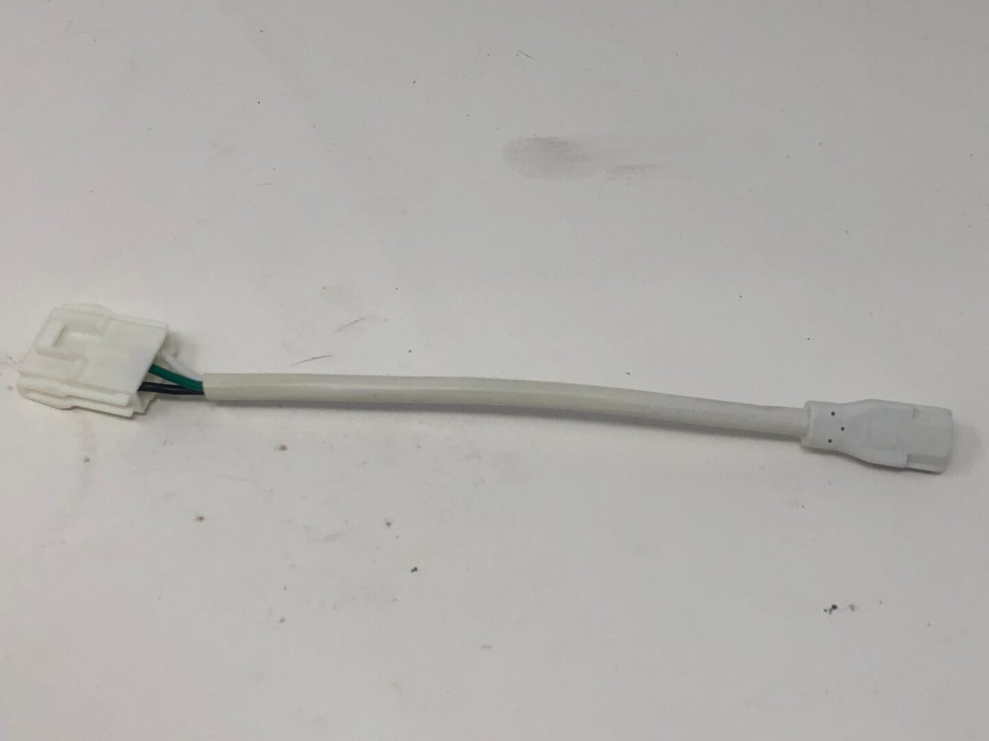 A white wire with a Plug Assembly, HMM attached to it.