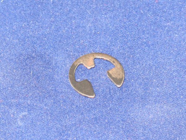 A metal E-ring on a blue surface.