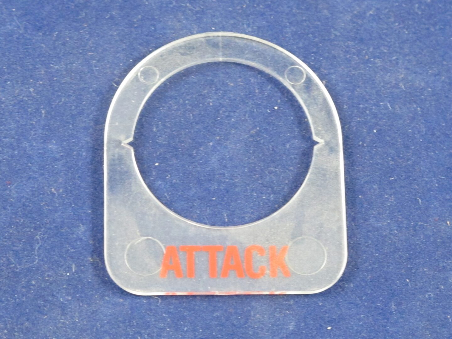 A plastic tag with the Attack Button Label on it.