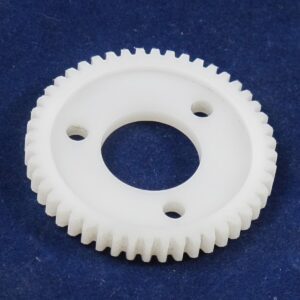 A white clutch gear on a blue surface.