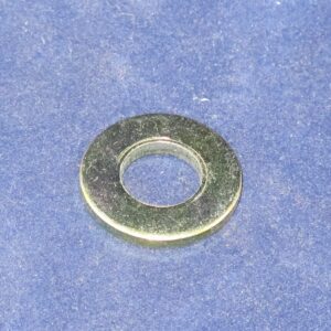 A metallic flat washer on a blue surface.