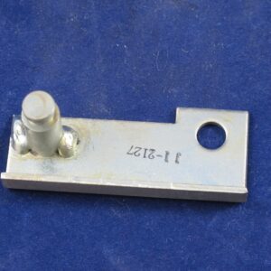 Metal bracket with a bolt and hole on a blue surface.