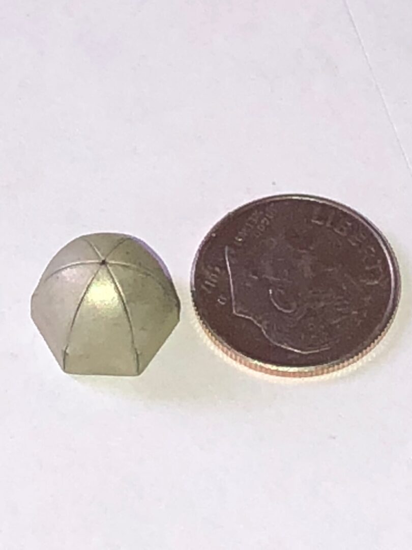 A small dome next to a coin.