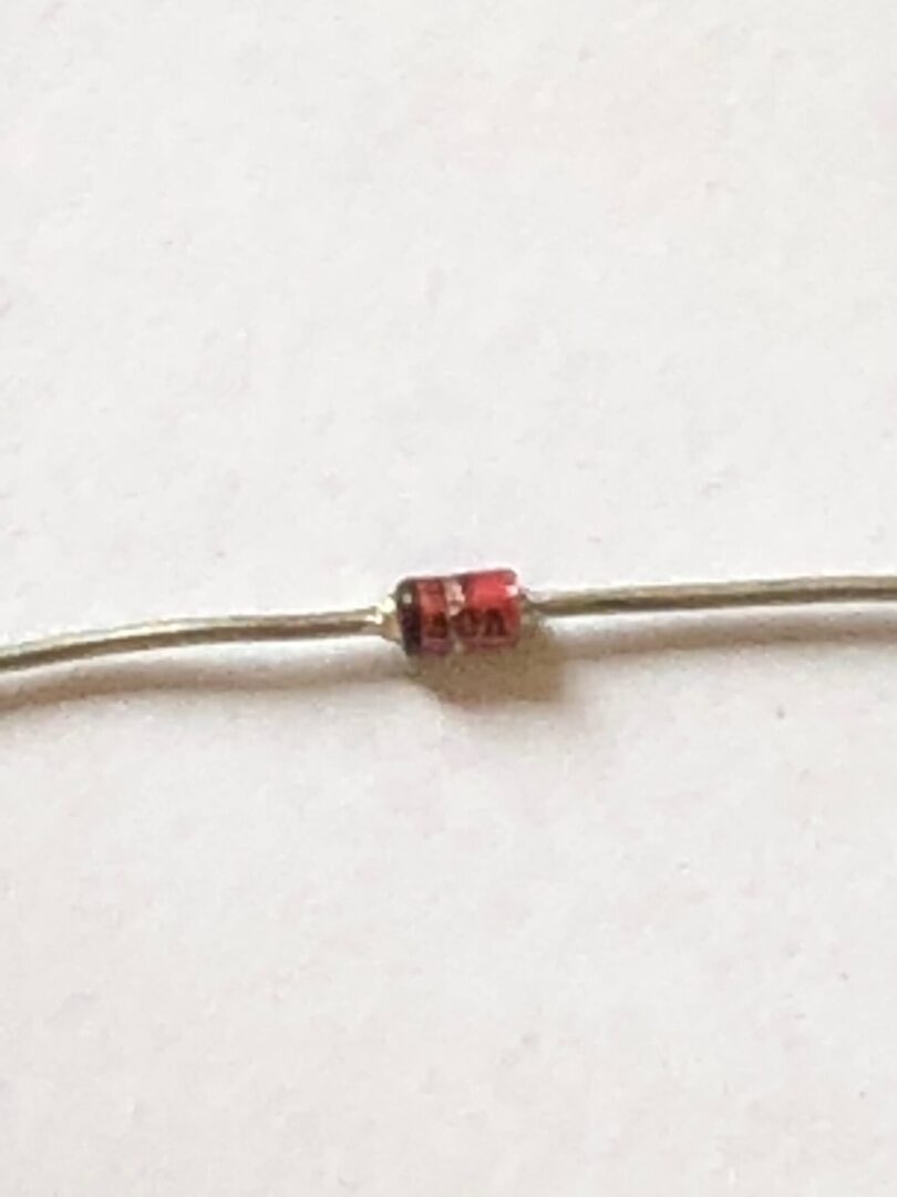 A small red resistor on a white surface.