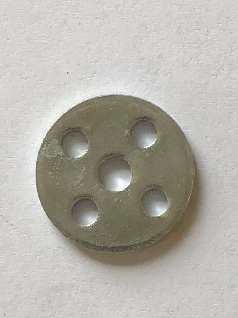 A round metal object with holes.